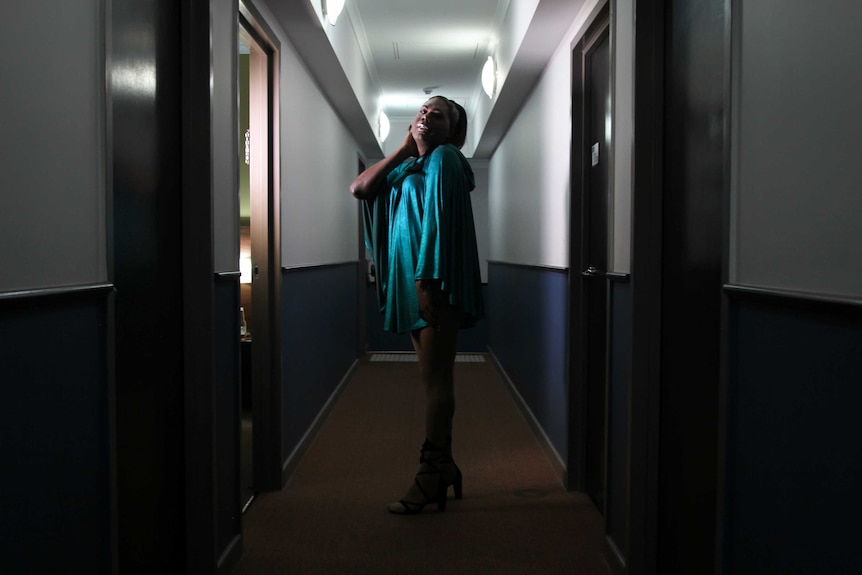 A photo of Tiwi Islands drag queen Shaniqua standing in a hotel corridor.