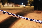 A close-up shot of police tape on a street at night.