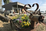 Iron planters in the shapes of dogs filled with flowers.