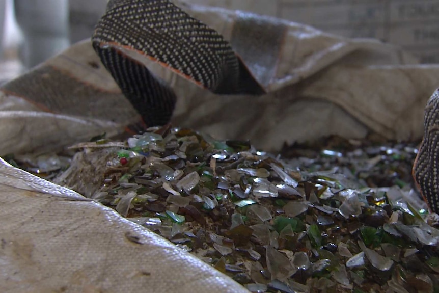 An open bag filled with hundreds of shards of coloured glass.