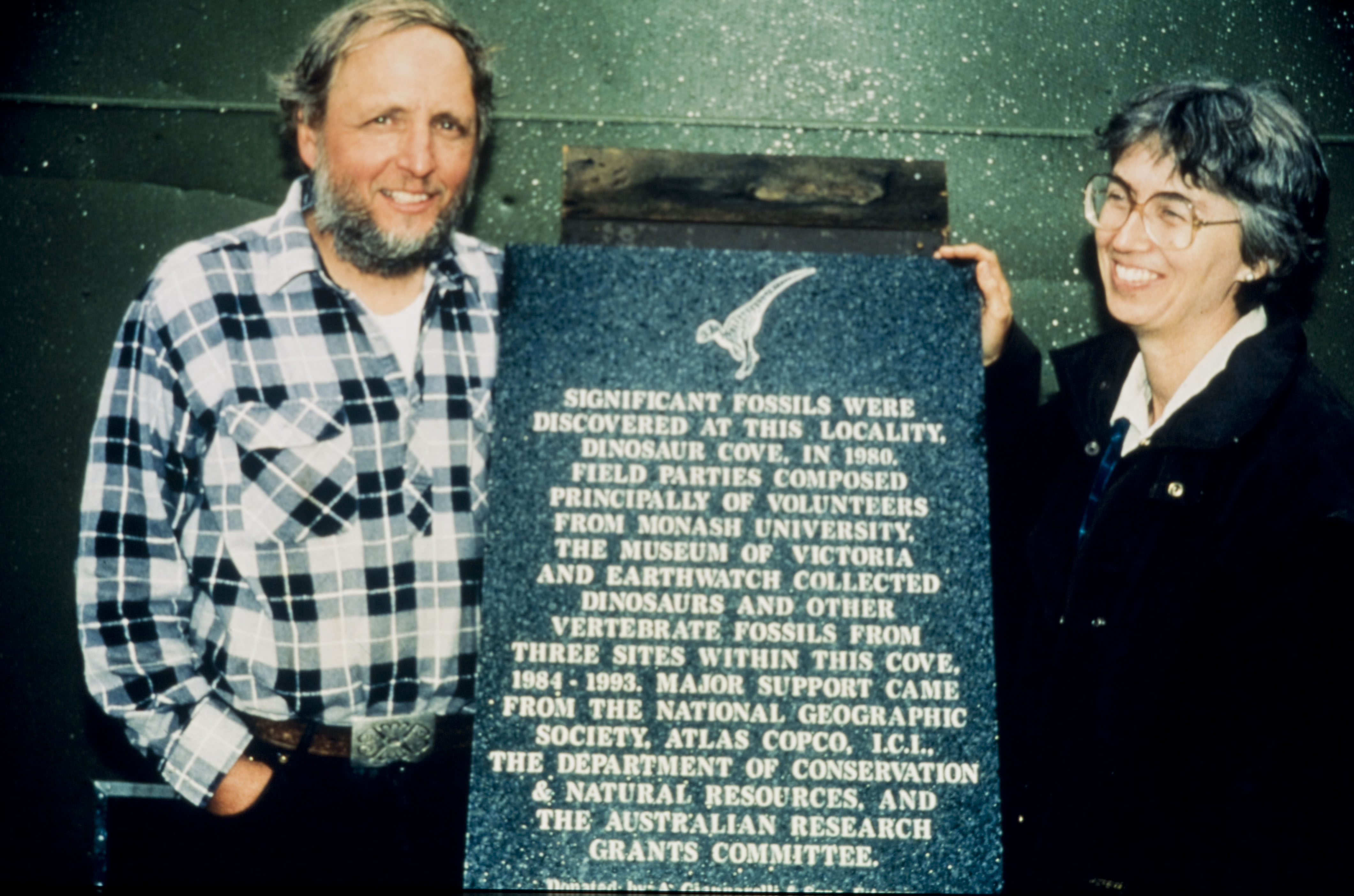 Two paleaontologists with a plaque honouring their work. 