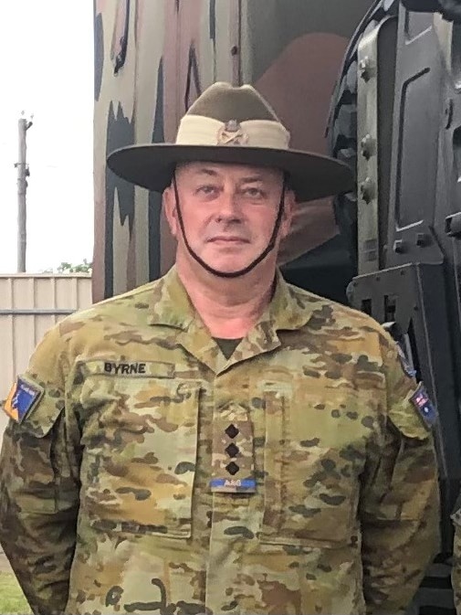 A man wearing an army cadet uniform with a wide brim hat