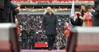 Vladimir Putin walks among supporters applauding him