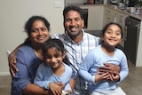 Tamil asylum seeker family the Nadesalingams smile and hug in their home.