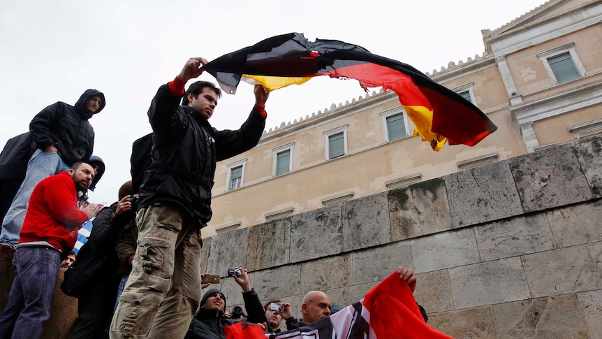 Greek anti-austerity protesters prepare to burn a German flag