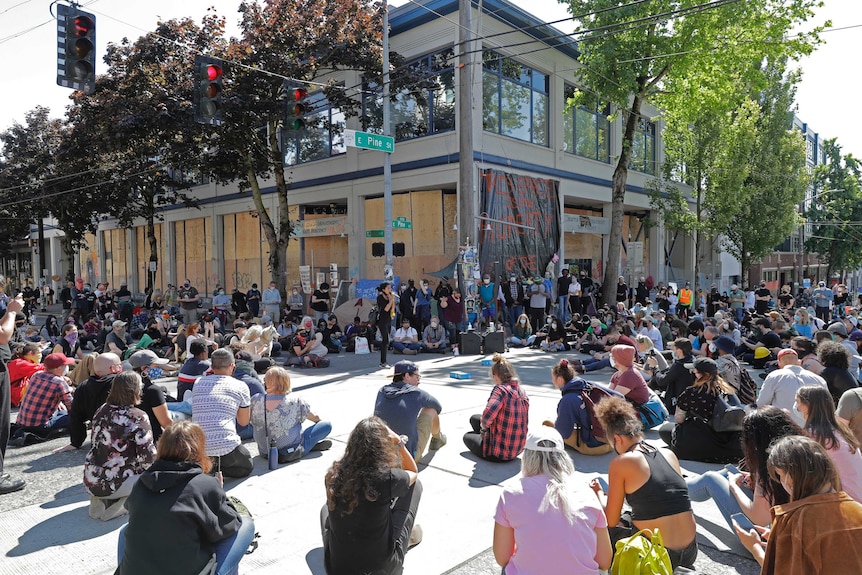 A group of people sitting on a street corner