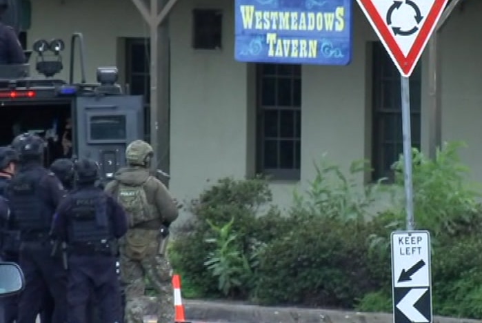 Police in black special operations and green camoflage stand outside the Westmeadows Tavern.