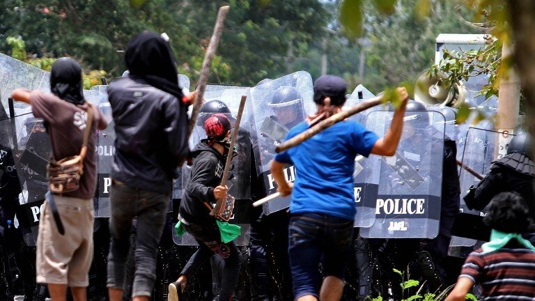 Police clash with protesting rubber farmers blocking a road in southern Thailand