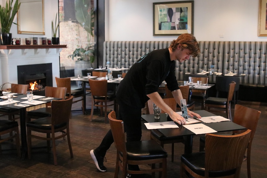Restaurant worker sets table. 