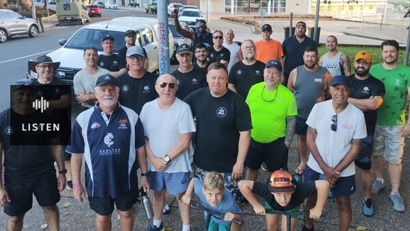 a group of 20 men of different ages wearing sports gear getting ready to walk along a street in Darwin. Has Audio.