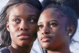 Two African American teen girls looking thoughtful