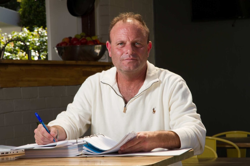 A man studying at a kitchen table.