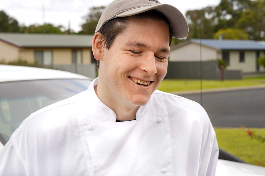 Ben Juste in his frontyard in front of his car