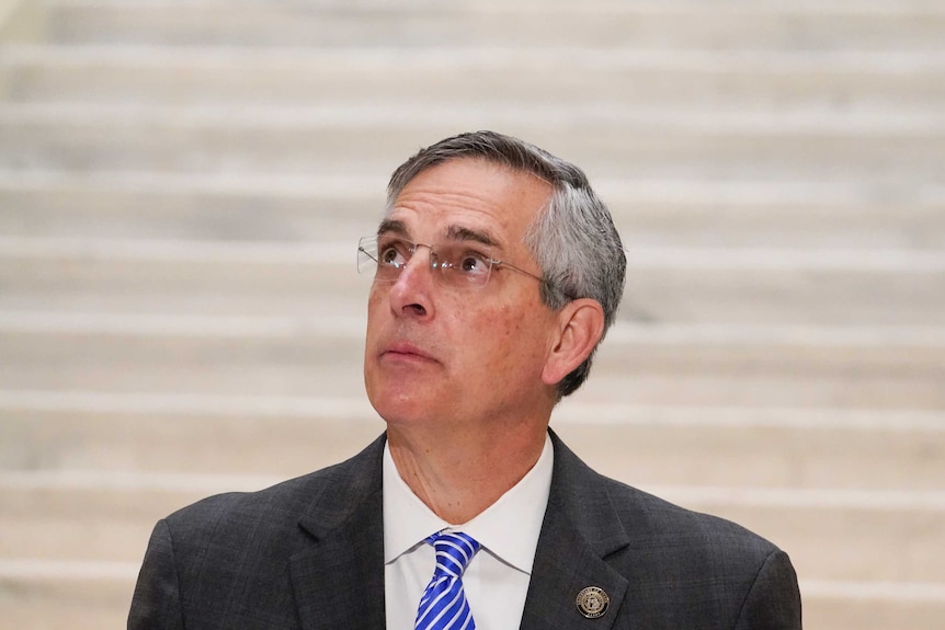 Georgia Secretary of State Brad Raffensperger looks up towards the ceiling as he speaks during a news conference