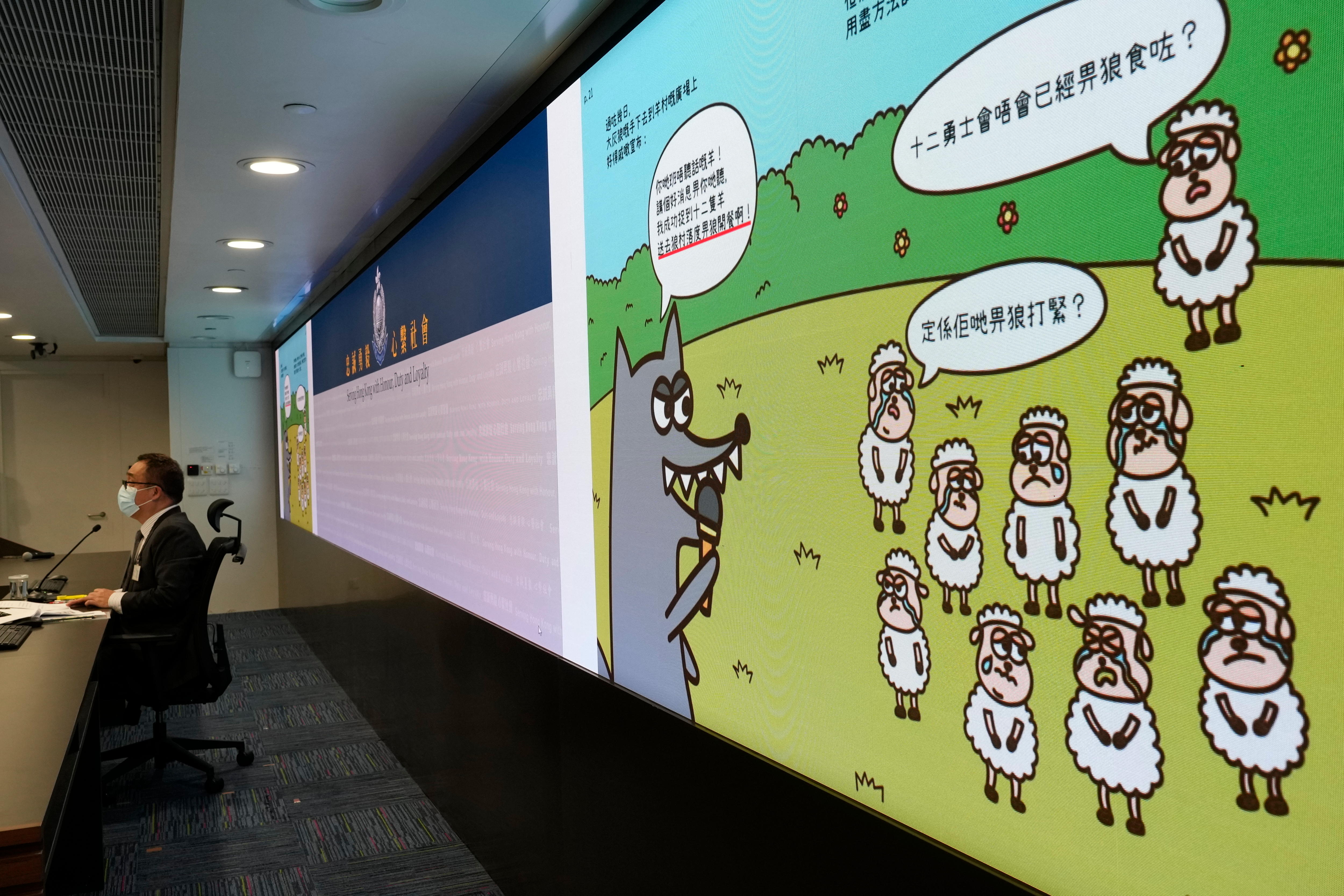 A man sits in front of a screen showing cartoons 