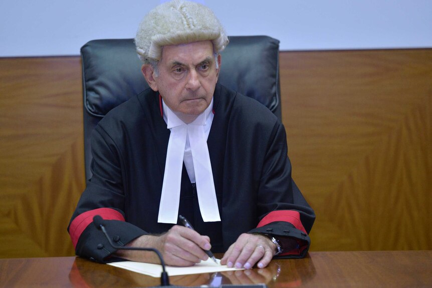 Acting Justice Anthony Graham sitting at the bench, looking stern.