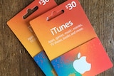 Two iTunes gift cards placed on a table.