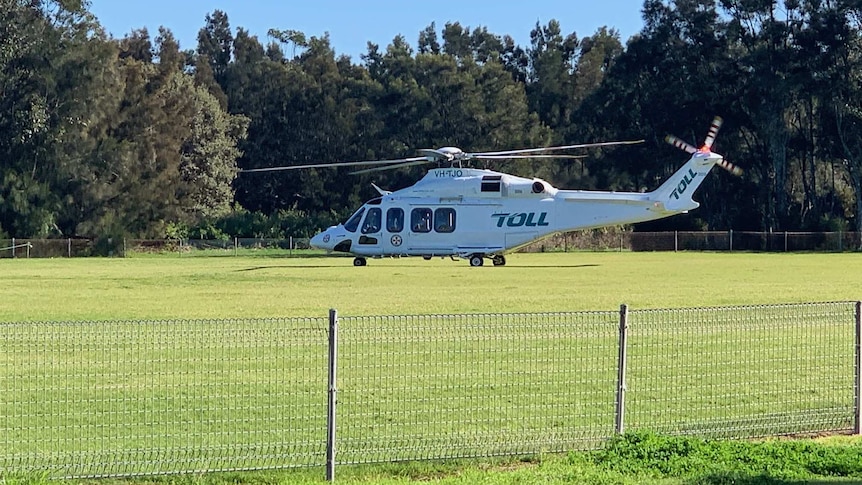 Ambulance rescue helicopter about to take off from Shellharbour Oval on sunny day.