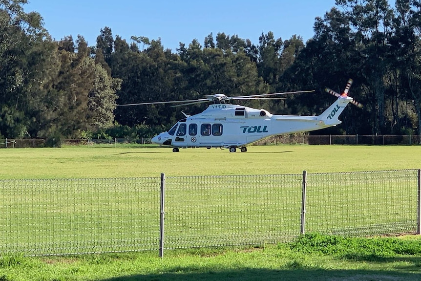 Ambulance rescue helicopter about to take off from Shellharbour Oval on sunny day.