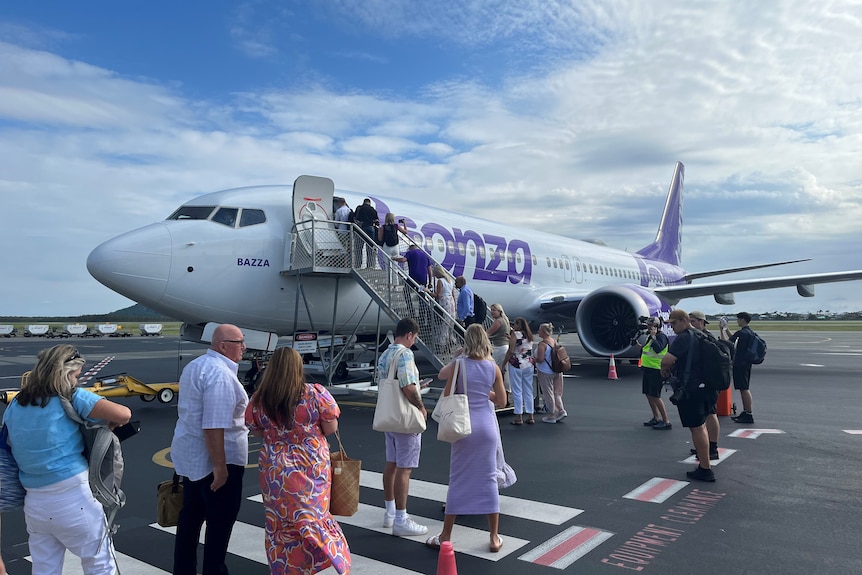 People board plane on tarmac