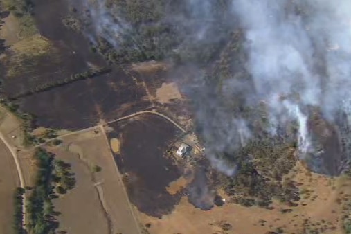 Aerial of grassfire north of Melbourne threatening homes