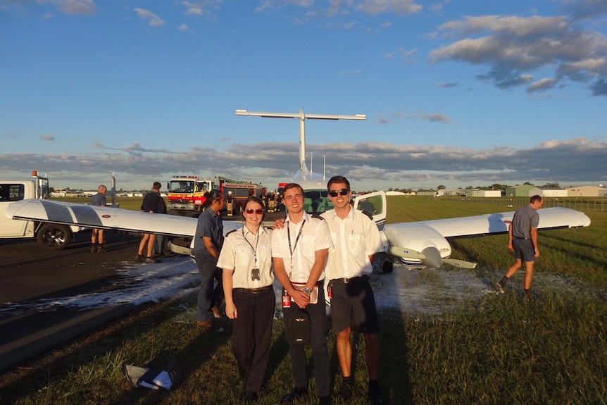 Pilot Zac Cox and two passengers in front of the plane that made an emergency landing.
