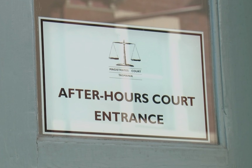 A sign reads "after-hours court entrance" on a door, on the outside of the Hobart Magistrates Court.