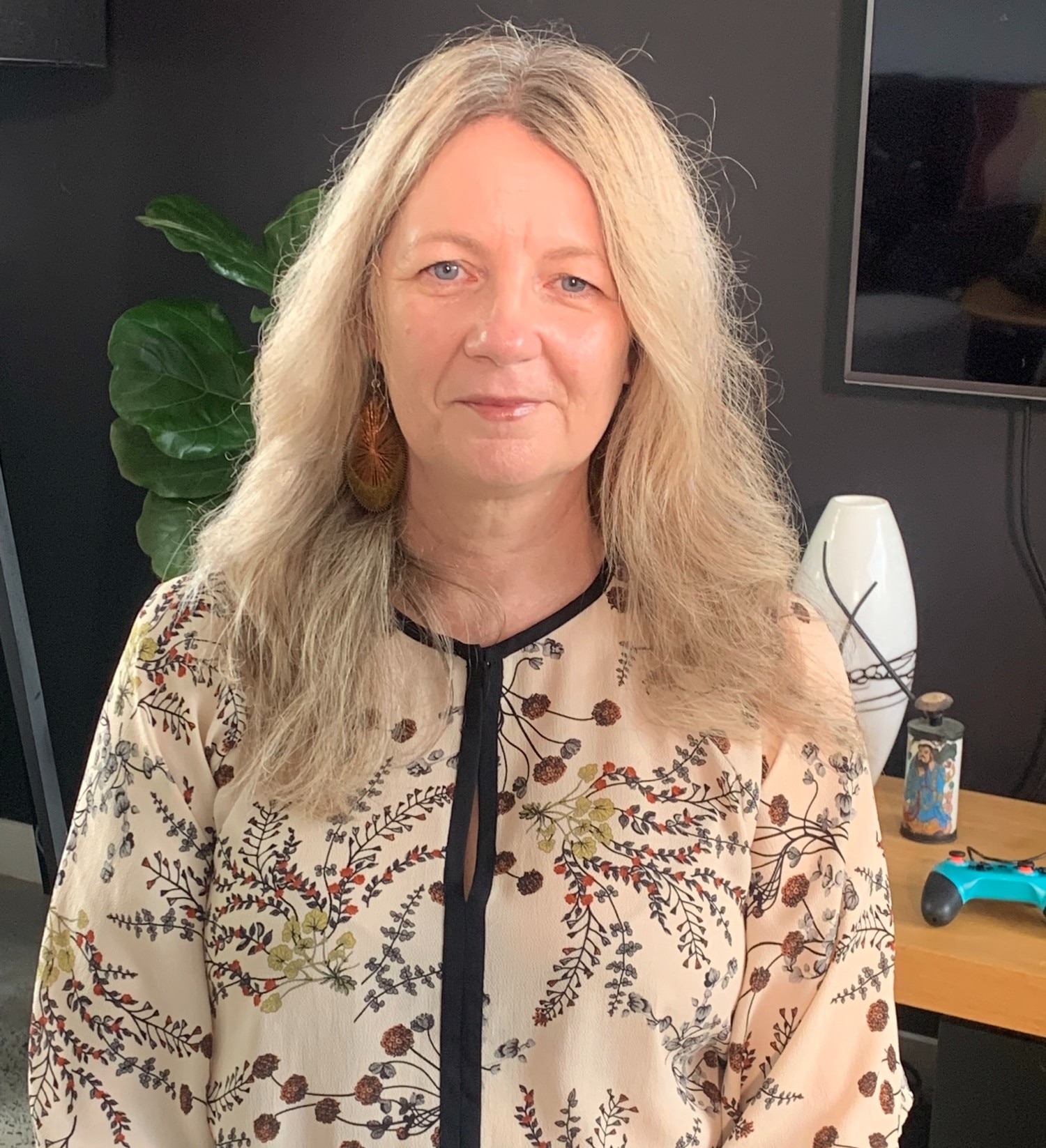 A woman with blonde hair smiles at the camera