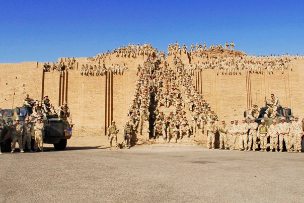 Soldiers in desert uniform pose on a ziggurat in Iraq