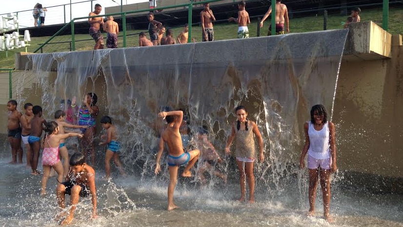 Children play in a water feature in Madureira Park.