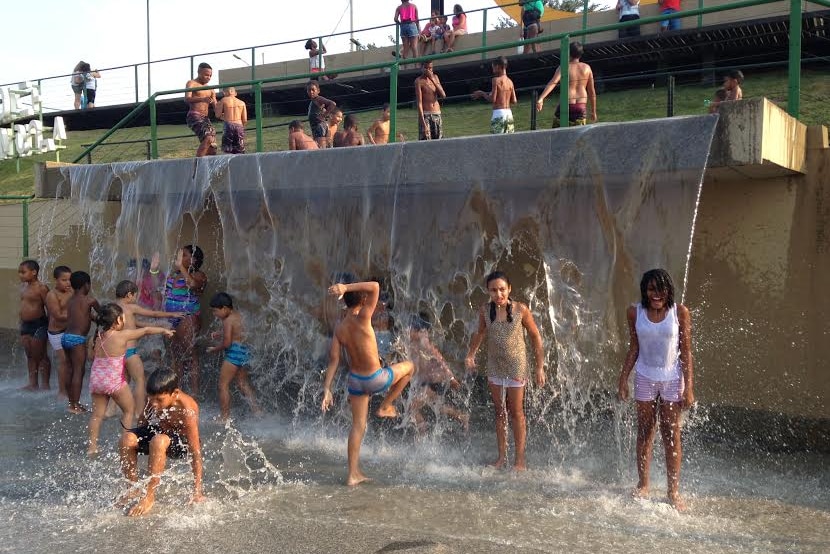 Children play in a water feature in Madureira Park.