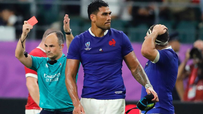 Jaco Peyper holds up a red card and points with his other hand as Sebastien Vahaamahina walks away