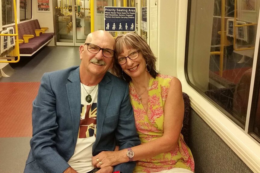 Jo Herbert and Dave Couton smiling for a photo on a train