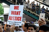 A crowd of Muslim community members gather in New York holding a sign that reads "we want justice".