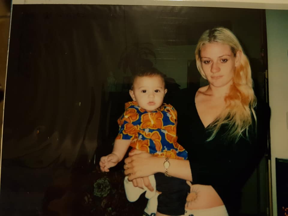 A woman holding a baby in a lounge room