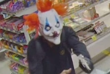 A man robs a store wearing a clown mask