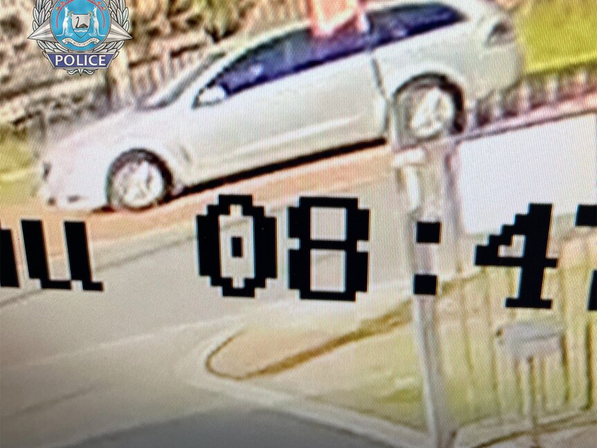 A grainy photo taken from CCTV of a silver Holden Commodore wagon.