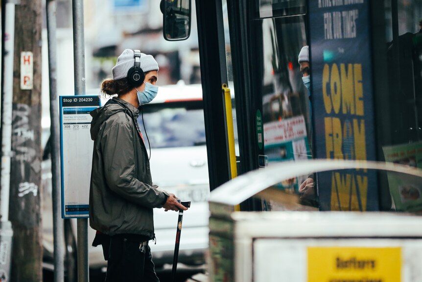 Man in mask entering bus