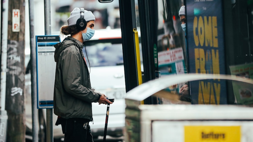 Man in mask entering bus