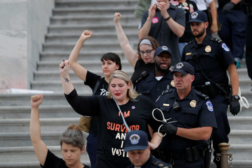 Police arrest four female protesters on the steps of the US Senate.