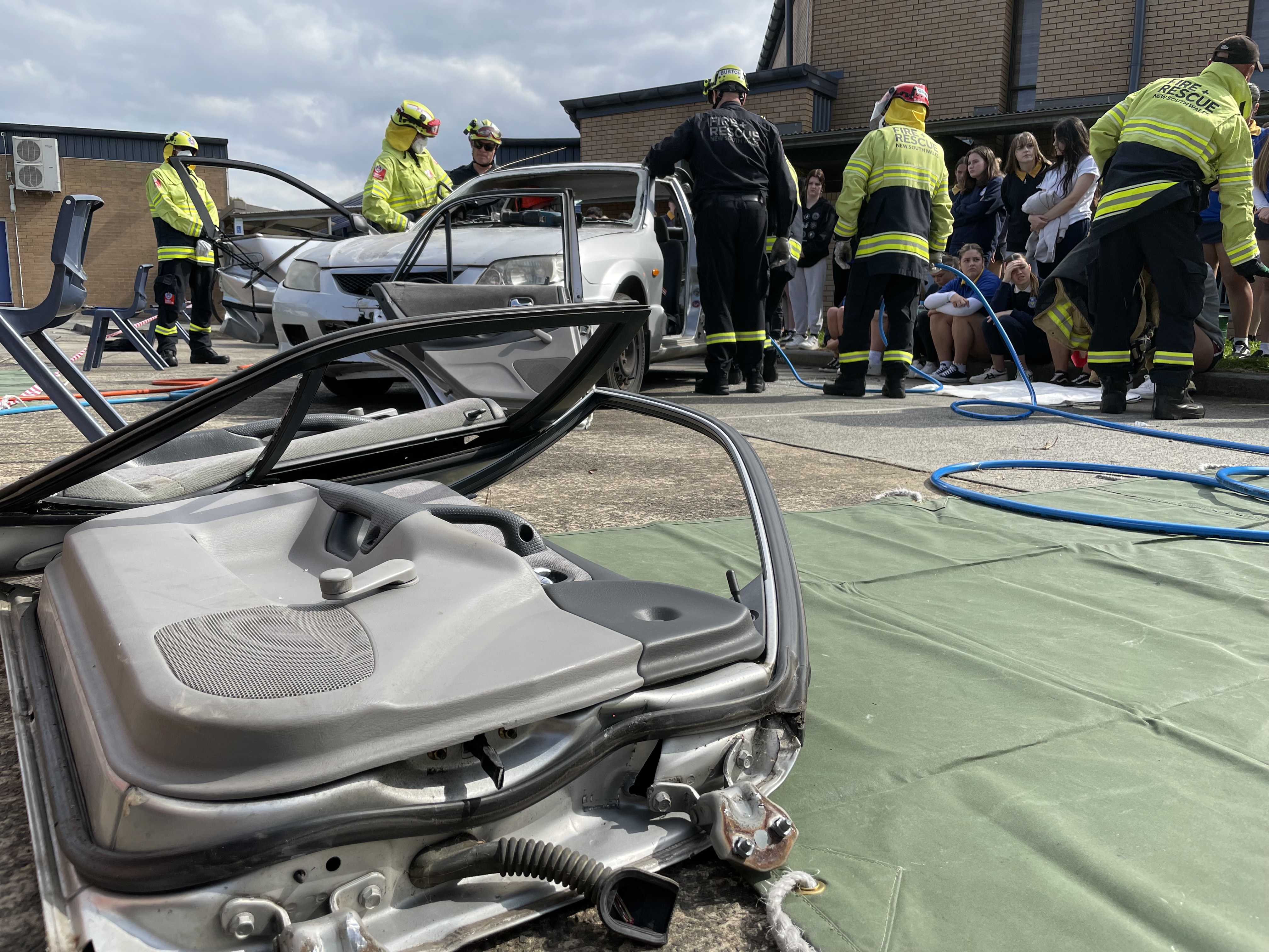 car doors lie on ground, firefights in background cutting car