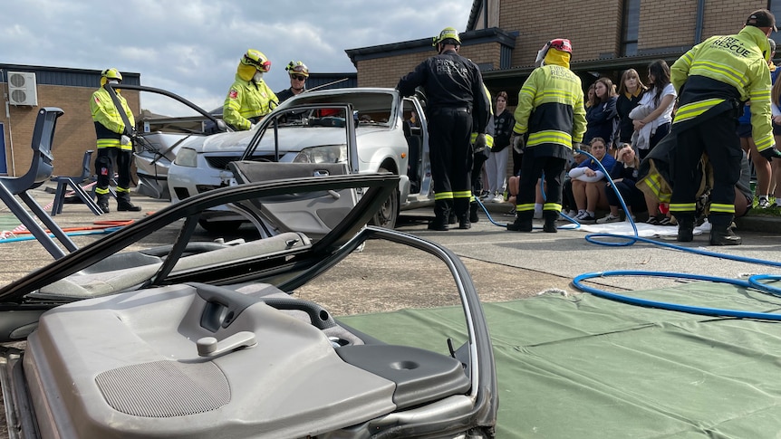 car doors lie on ground, firefights in background cutting car