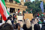 a group of people out the front of a building holding flags