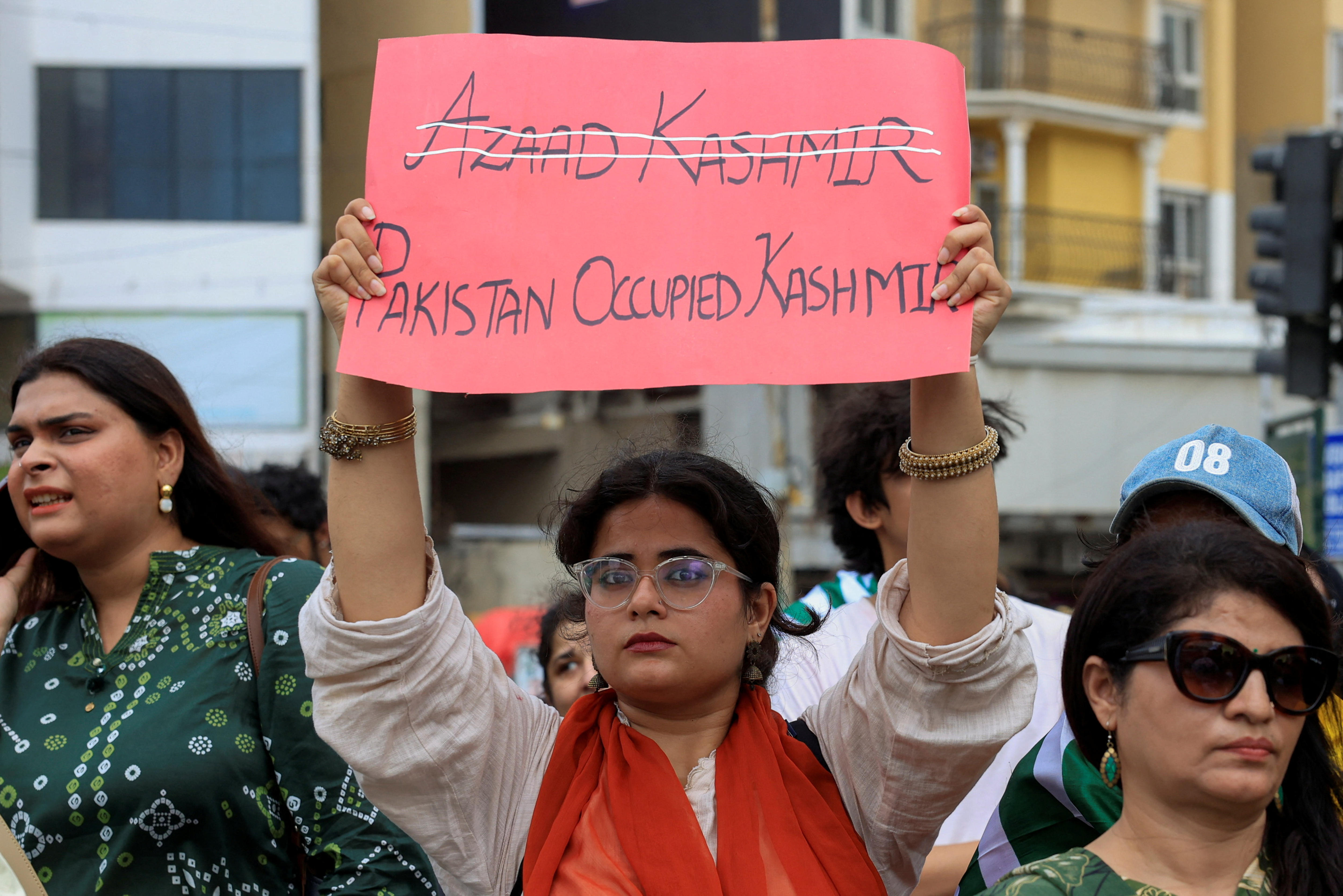 A woman holds up coloured cardboard with a message written on it