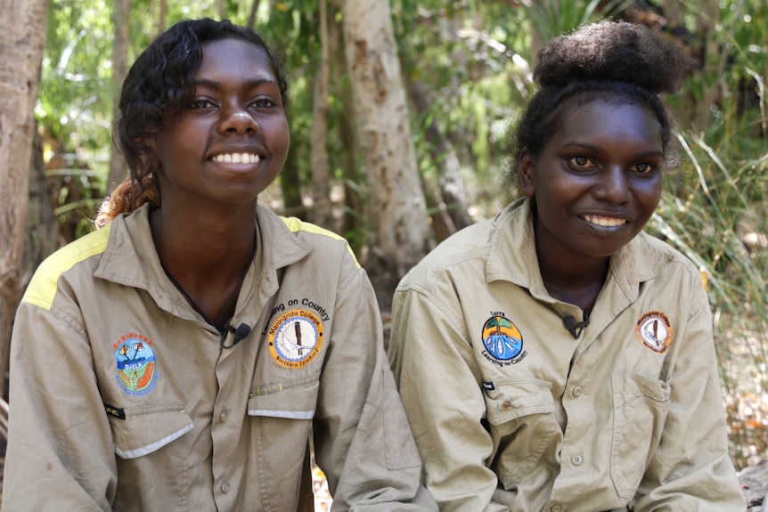 Two young girls are smiling. 