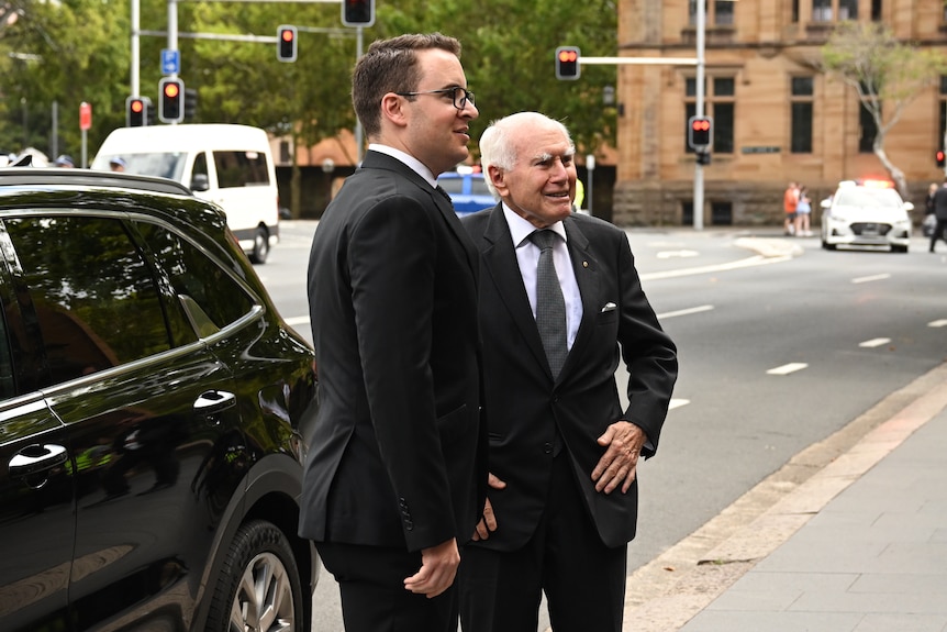 Two men wearing black suits