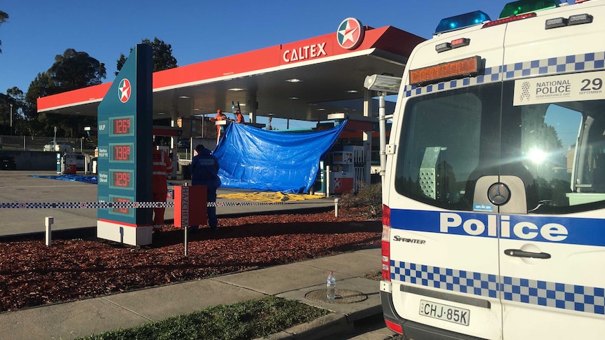 Emergency services workers and police at the scene of a stabbing, a Queanbeyan service station