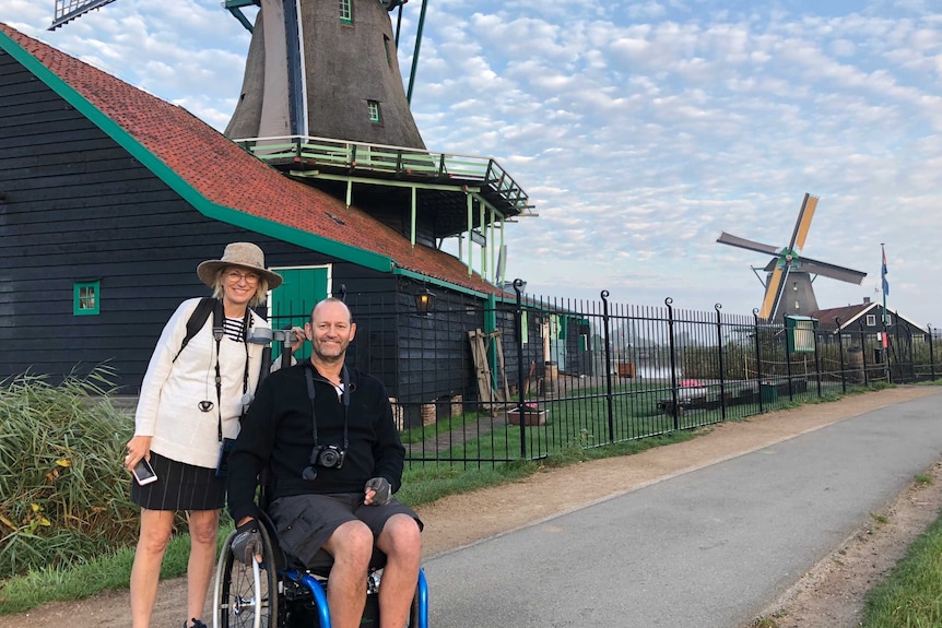 Woman stands next to a man in a wheelchair in Amsterdam.