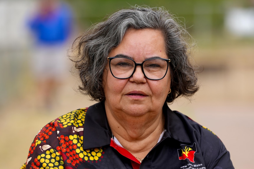 A woman with glasses looking at the camera