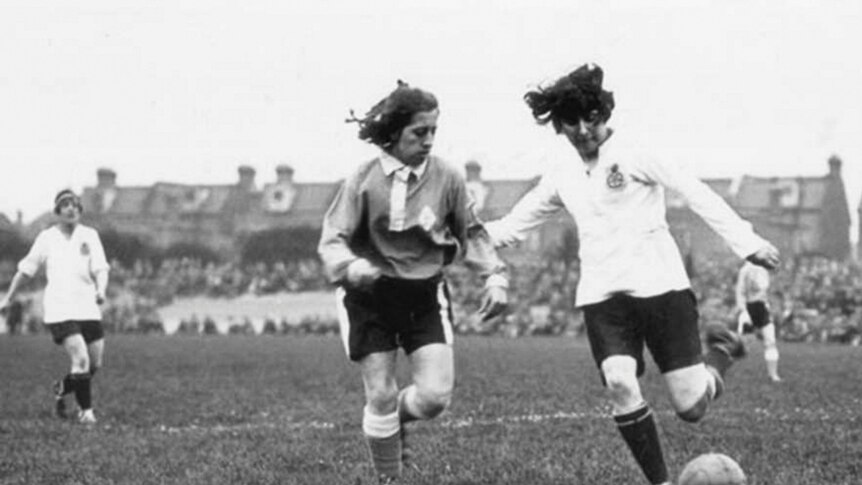 Two women playing soccer in the 1920s.